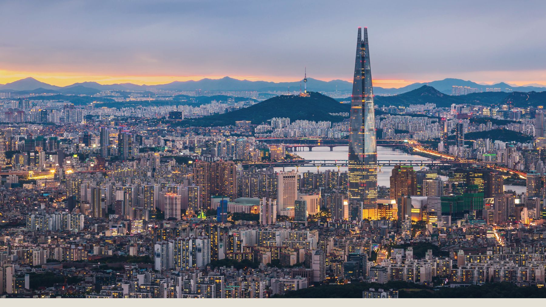 Seoul skyline at dusk with Lotte World Tower rising above the Han River